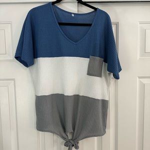 Color blocked tee shirt. Waffle knit fabric. Pocket front. Tie in front.